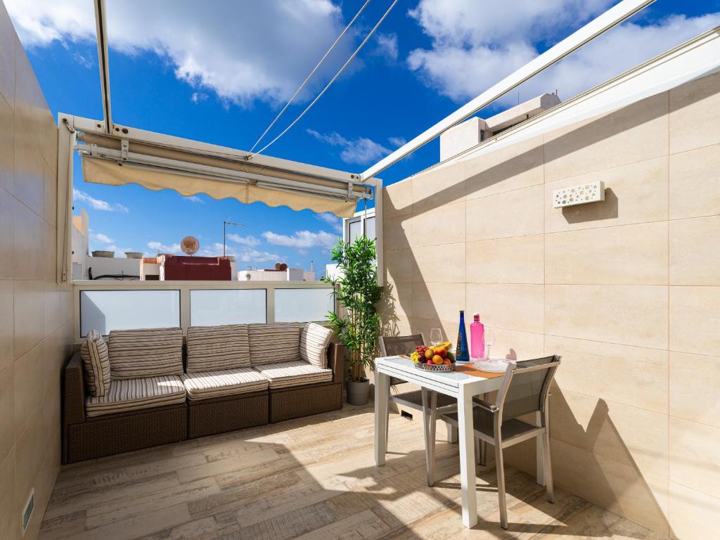 大加那利岛拉斯帕尔马斯Attico Albareda的小阳台,配有桌子和长凳