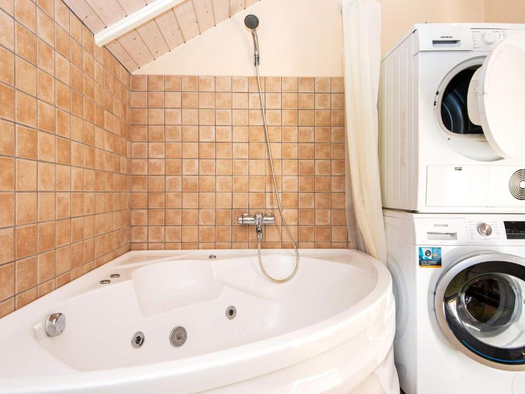 安斯艾厄Holiday home Ansager XXXIX的带浴缸和洗衣机的浴室。