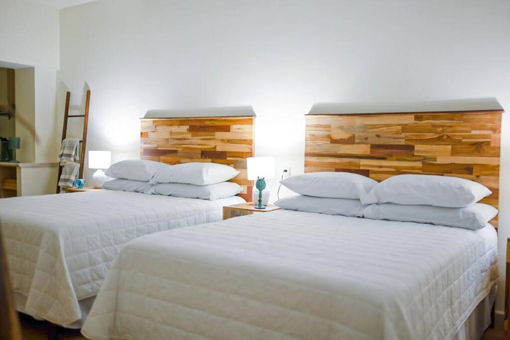 弗洛勒斯Recently Renovated Apartment The Heart Of Flores的卧室内的两张床,配有白色床单和枕头