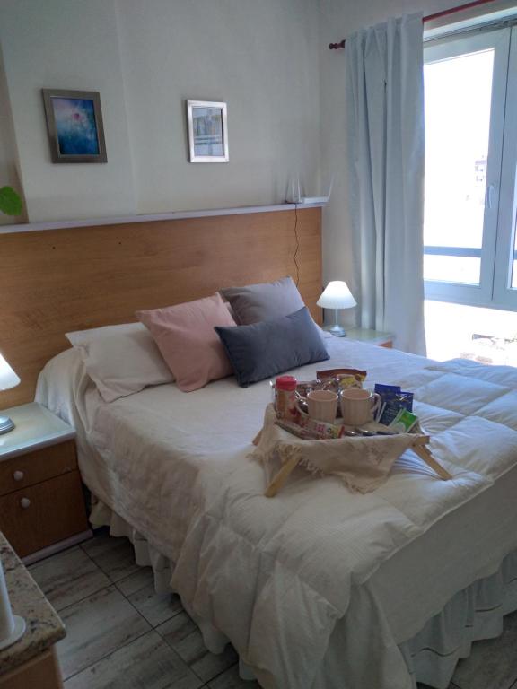 罗萨里奥Arcángeles的一间卧室配有一张床,上面放着一个食物托盘
