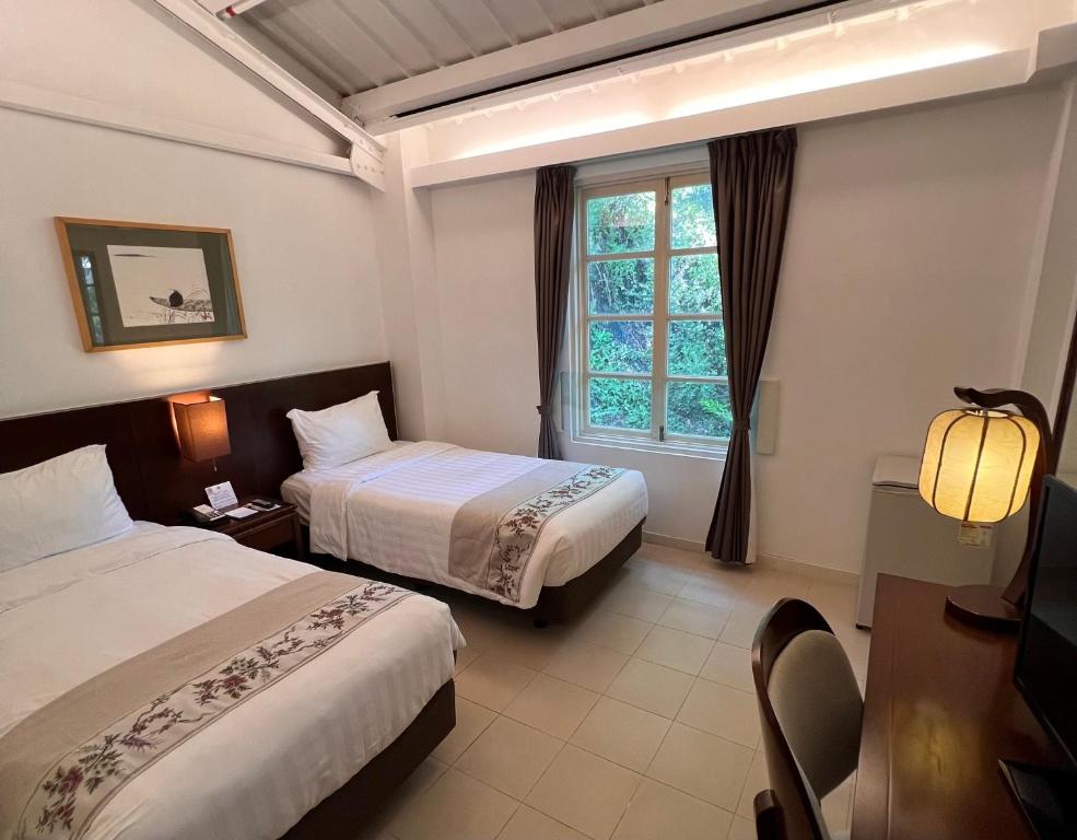 香港文化旅館 - 翠雅山房的酒店客房设有两张床和窗户。