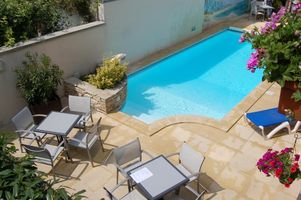 兰斯Logis Hotel au tambour的享有带桌椅的游泳池的顶部景致