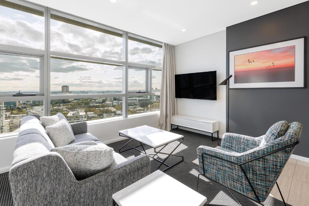 悉尼泽特兰美利通公寓式酒店的客厅配有两张沙发和一台电视机