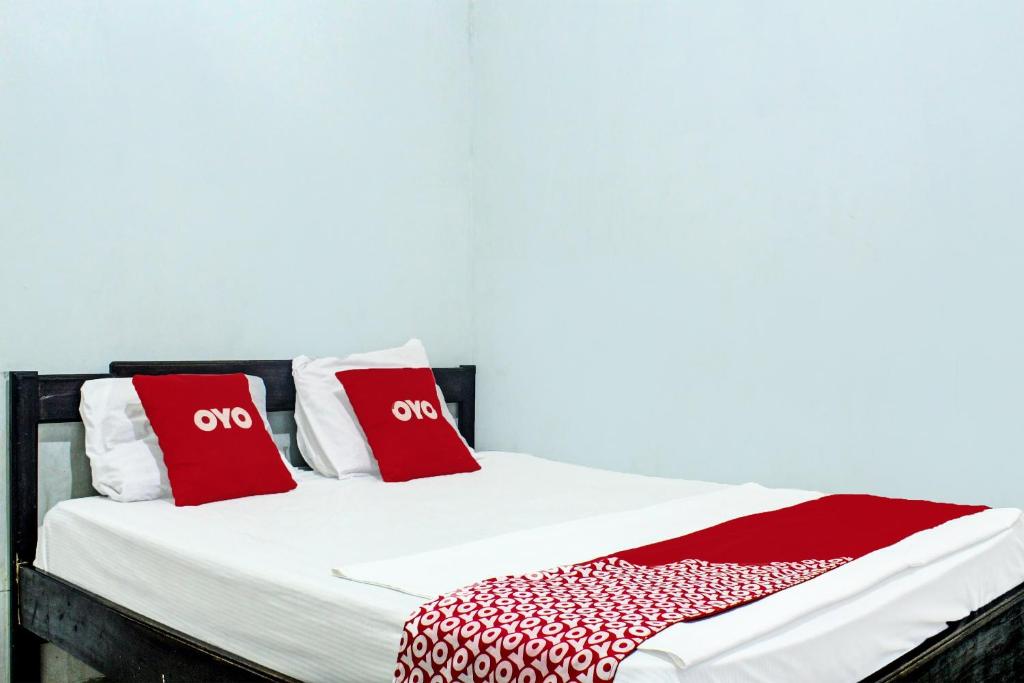 古邦OYO 91720 Hotel Yotowawa的一张带红色和白色枕头的床
