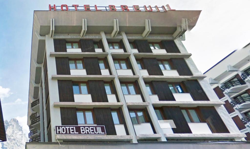 布勒伊-切尔维尼亚Hotel Breuil的上面有酒店美人 ⁇ 标志的酒店大楼