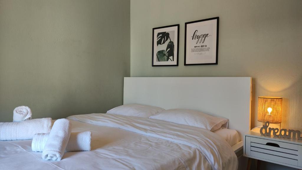 特里卡拉Hygge Home at Trikala的卧室配有白色床和毛巾