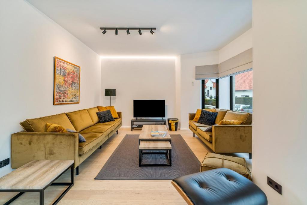 科克赛德Sublieme, ruime luxe villa 10p met terras én tuin的客厅配有两张沙发和一台电视机