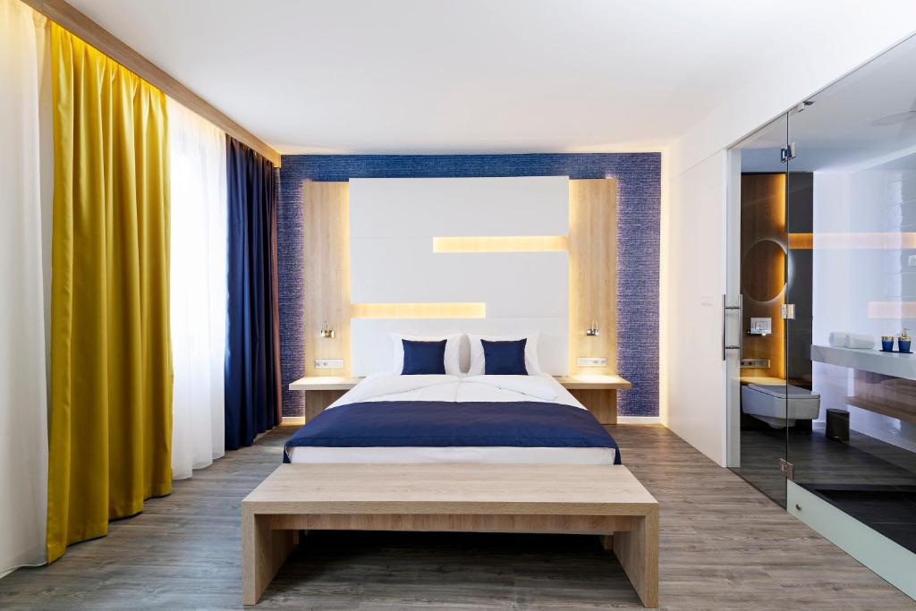 布达佩斯KViHotel Budapest - the smart hotel的一间卧室配有大床和黄色窗帘