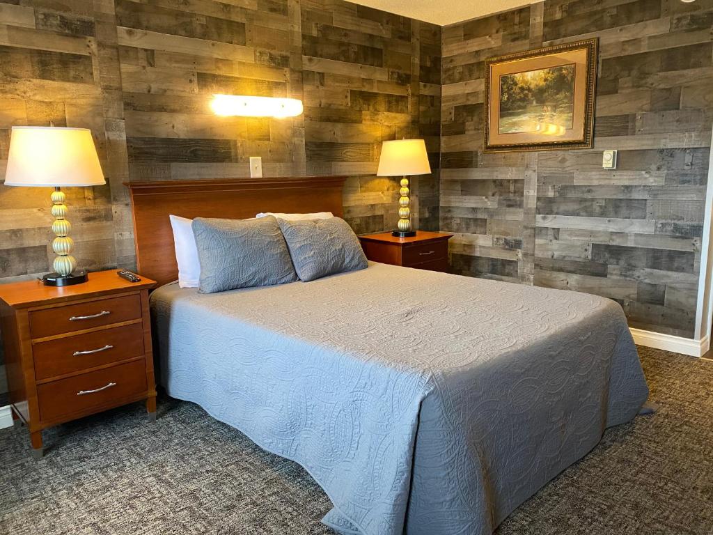 Pelican RapidsPelican Motel的一间卧室配有一张带2个床头柜和2盏灯的床。