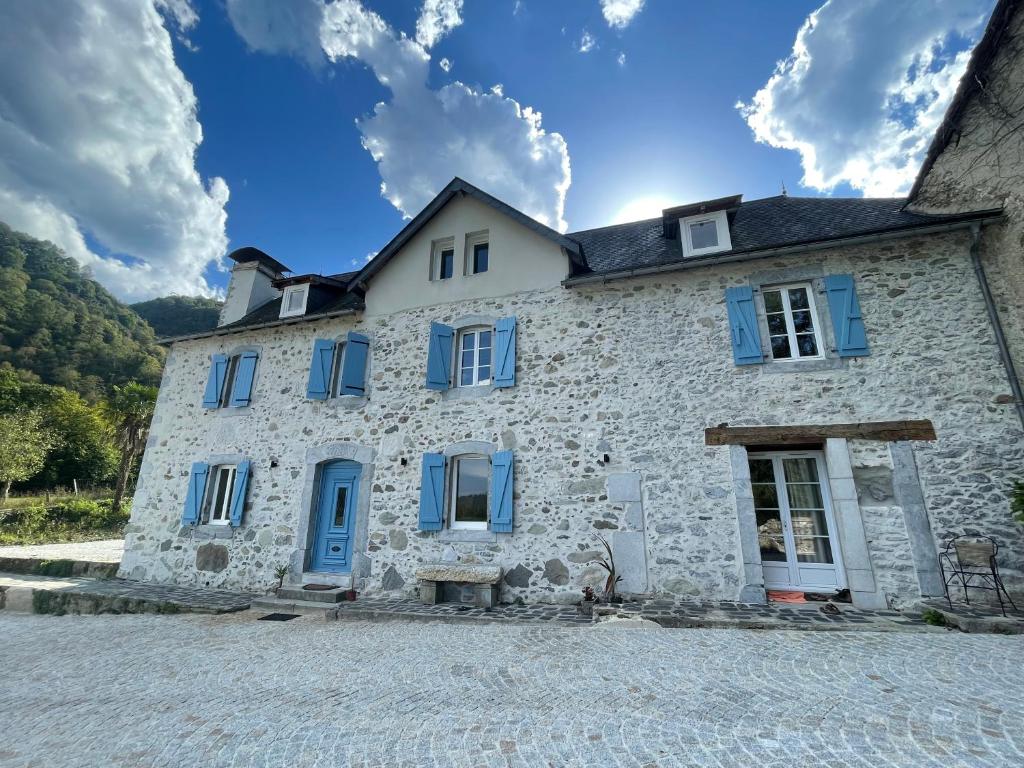 ArudyLe Val Éveillé 4 étoiles - maison de maître de 1773的 ⁇ 上带蓝色百叶窗的古老石屋