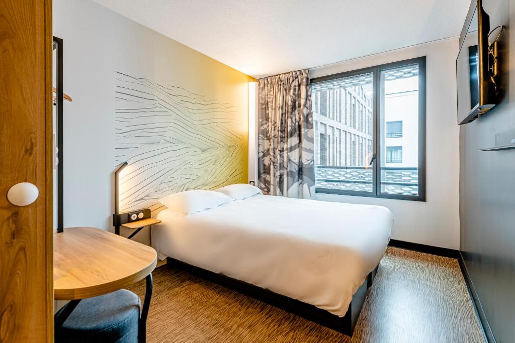 德勒B&B HOTEL Dreux Nord的酒店客房设有床和窗户。