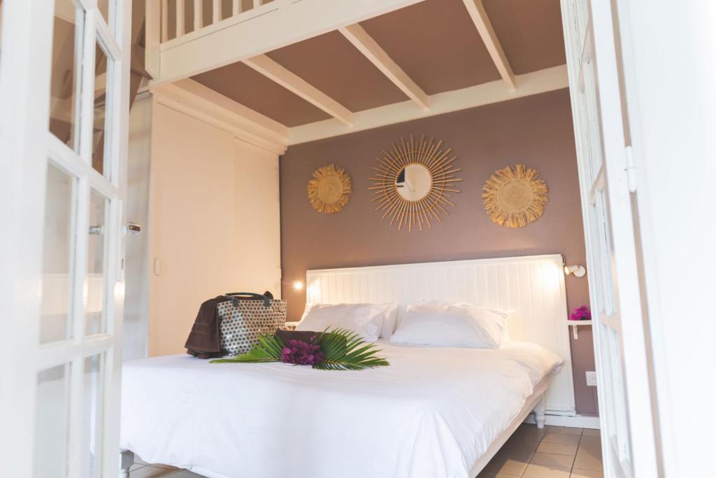 拉萨尔勒班Ilet du Lagon的卧室配有白色的床和墙上的镜子