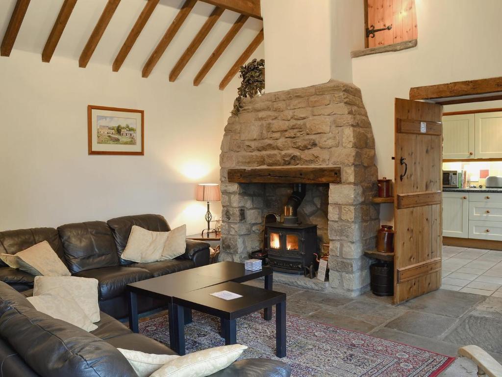 Hollinsclough春之屋乡村别墅的客厅设有石制壁炉和沙发。