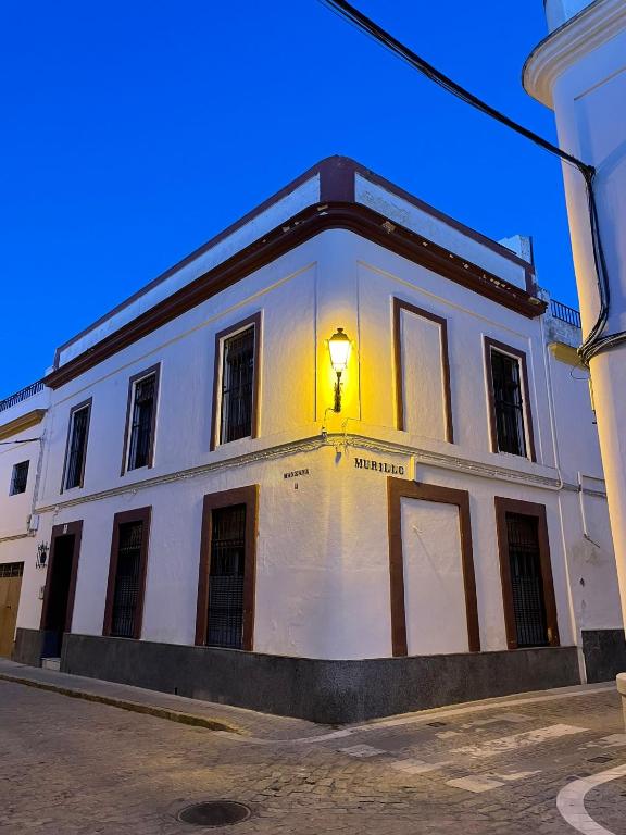 Lora del RíoCasa Los pinceles de Murillo的白色的建筑,边有灯