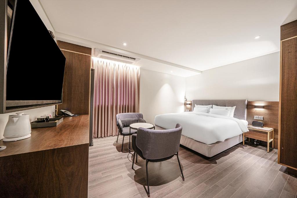 木浦市Hotel Yaja Mokpo Peace Square的配有一张床和一台平面电视的酒店客房