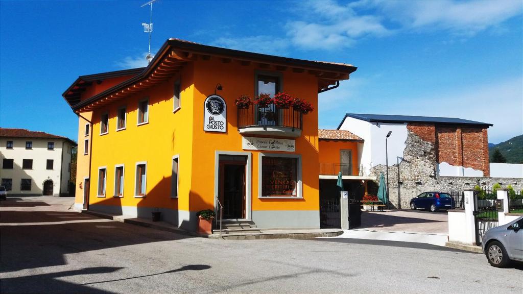 NimisAl Posto Giusto的黄色和橙色的建筑,设有阳台