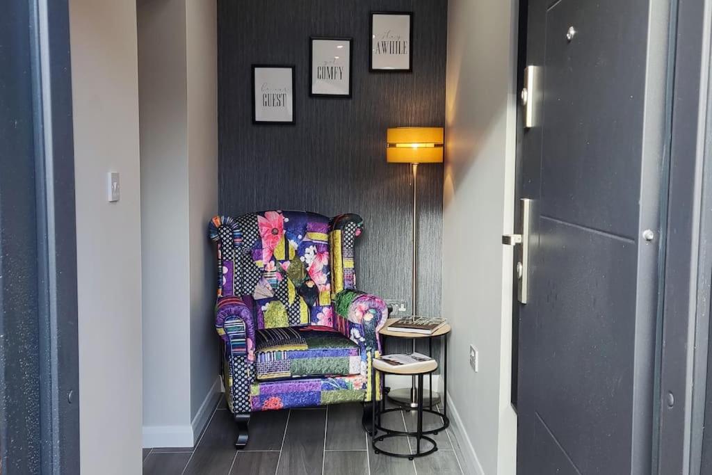 博勒姆伍德Comfortable 1 Bed flat with Air Con的走廊里一张五颜六色的椅子,边桌