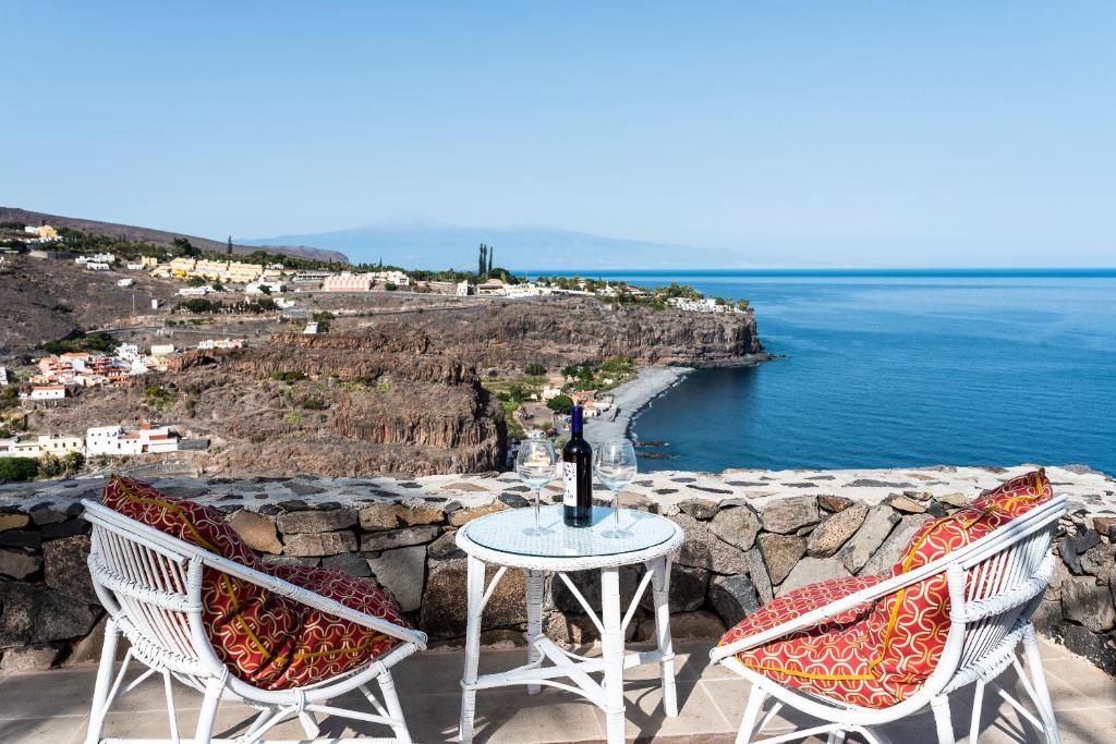 圣地亚哥海滩Casa Los Mangos - Increíbles vistas的两把椅子和一张桌子及一瓶葡萄酒