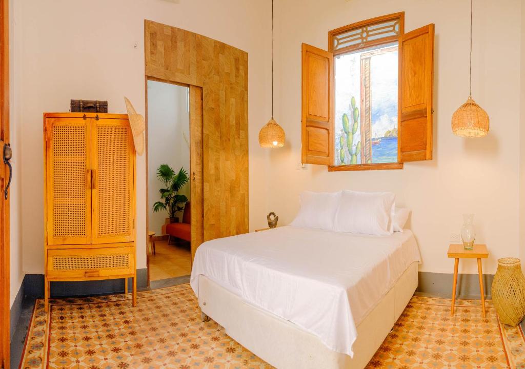 圣玛尔塔Casa Rosa - Alma Hotels的卧室配有白色的床和窗户。