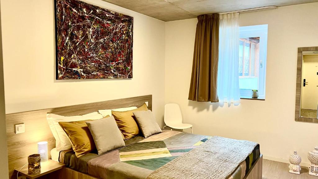 阿格诺Regina Bed & Breakfast的卧室配有一张床,墙上挂有绘画作品