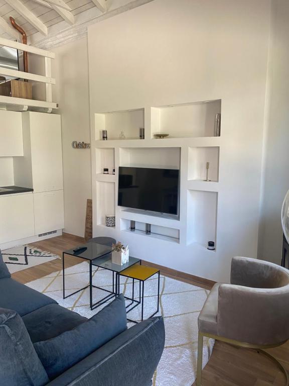 塞那哥La casetta的客厅配有沙发和墙上的电视