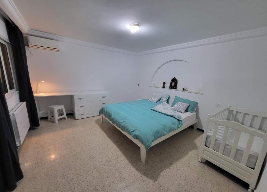 苏塞Écrin的一间白色卧室,配有一张床和一张婴儿床
