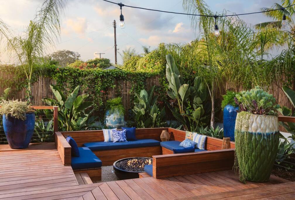 圣巴巴拉Tropical Beach Villa with Deck, Spa Walk to Ocean的天井配有沙发、蓝色椅子和植物