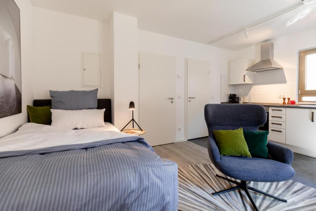 诺伊恩斯塔特阿姆科黑尔Appartement Champagne的一间卧室配有一张床和一张蓝色椅子