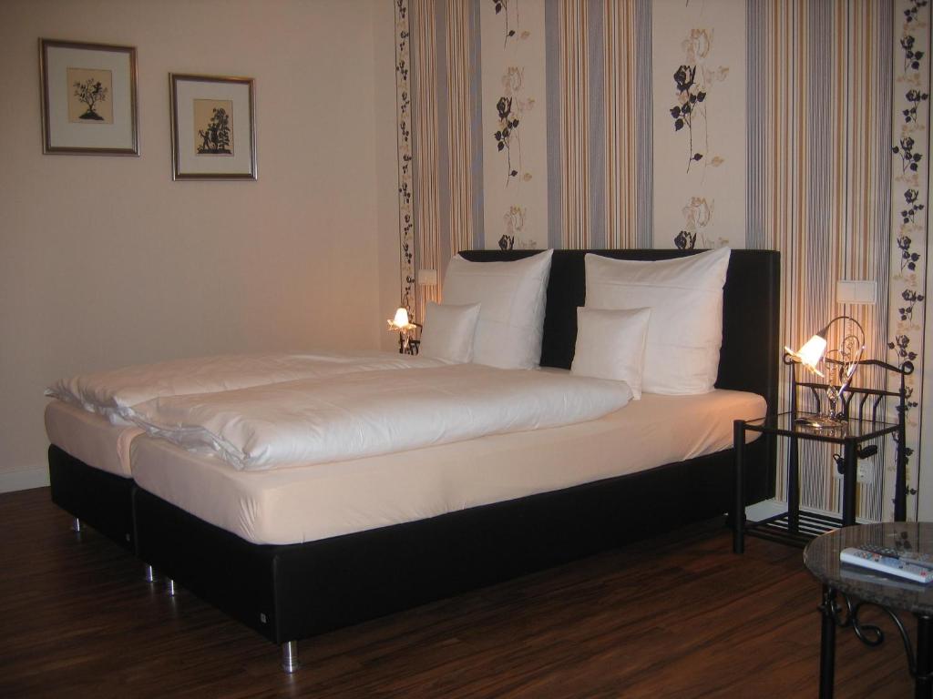 ForstGästehaus Oswald的一张带白色床单和枕头的床