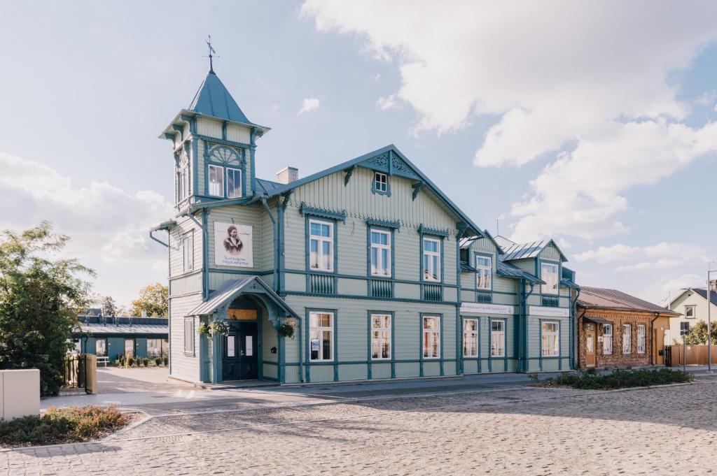 哈普萨卢Villa Fannyhof的一座蓝色和白色的大建筑,设有钟楼