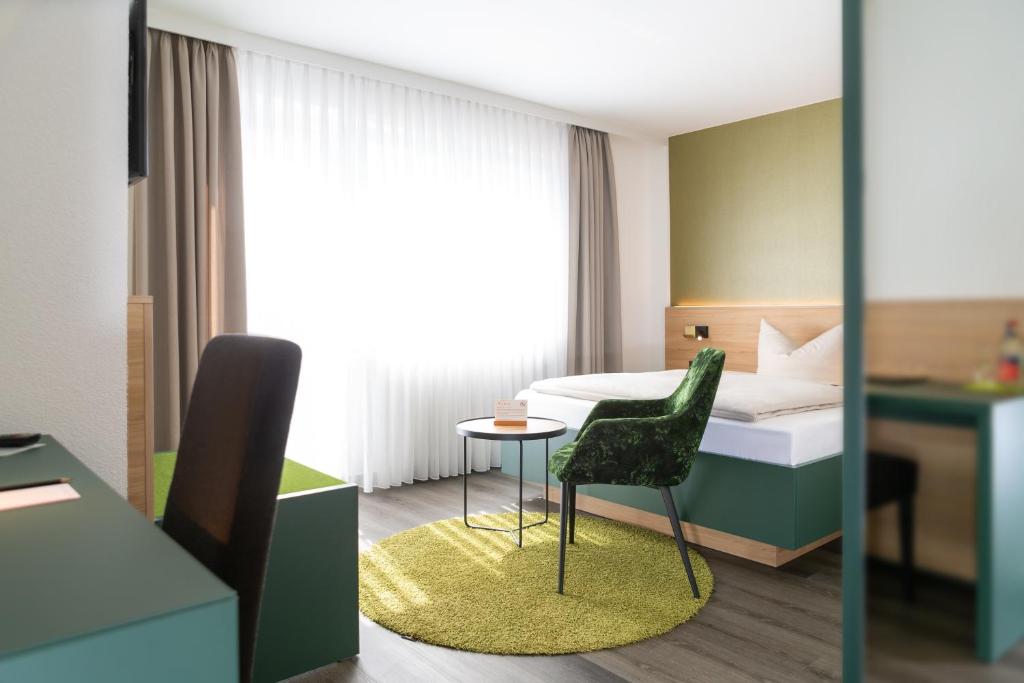 弗莱堡比尔豪斯尔餐厅酒店的一间卧室配有一张床、一把椅子和一张桌子