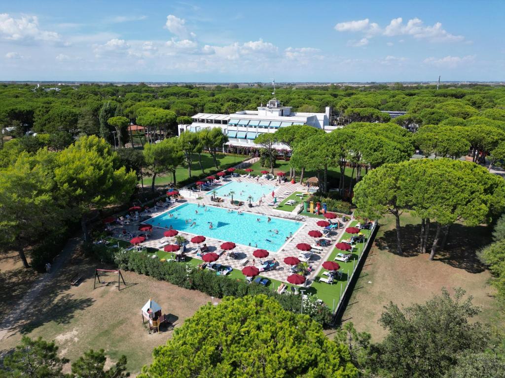 比比翁Il Tridente Camping Village的享有带椅子和遮阳伞的游泳池的上方景致