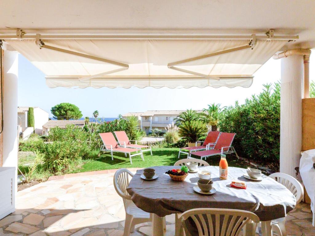 圣艾格夫Apartment Les Mas de la Mer-2 by Interhome的庭院配有桌椅和遮阳伞。