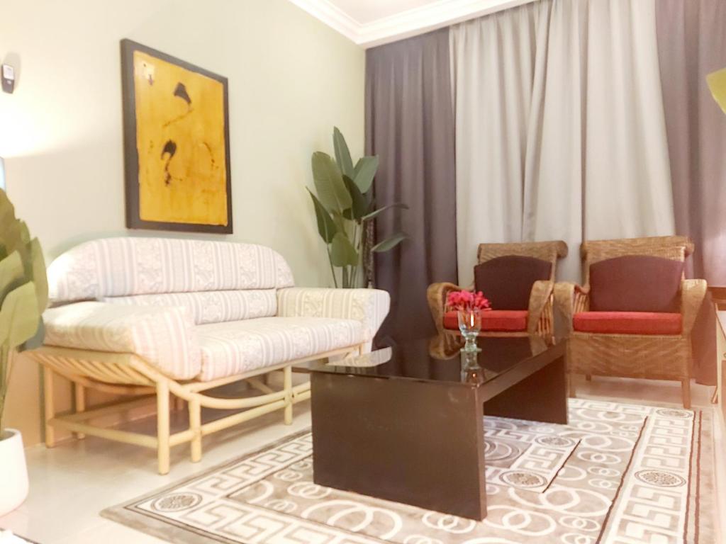 万挠Islamic Homestay Apartment Kundang, Rawang的客厅配有沙发和两把椅子