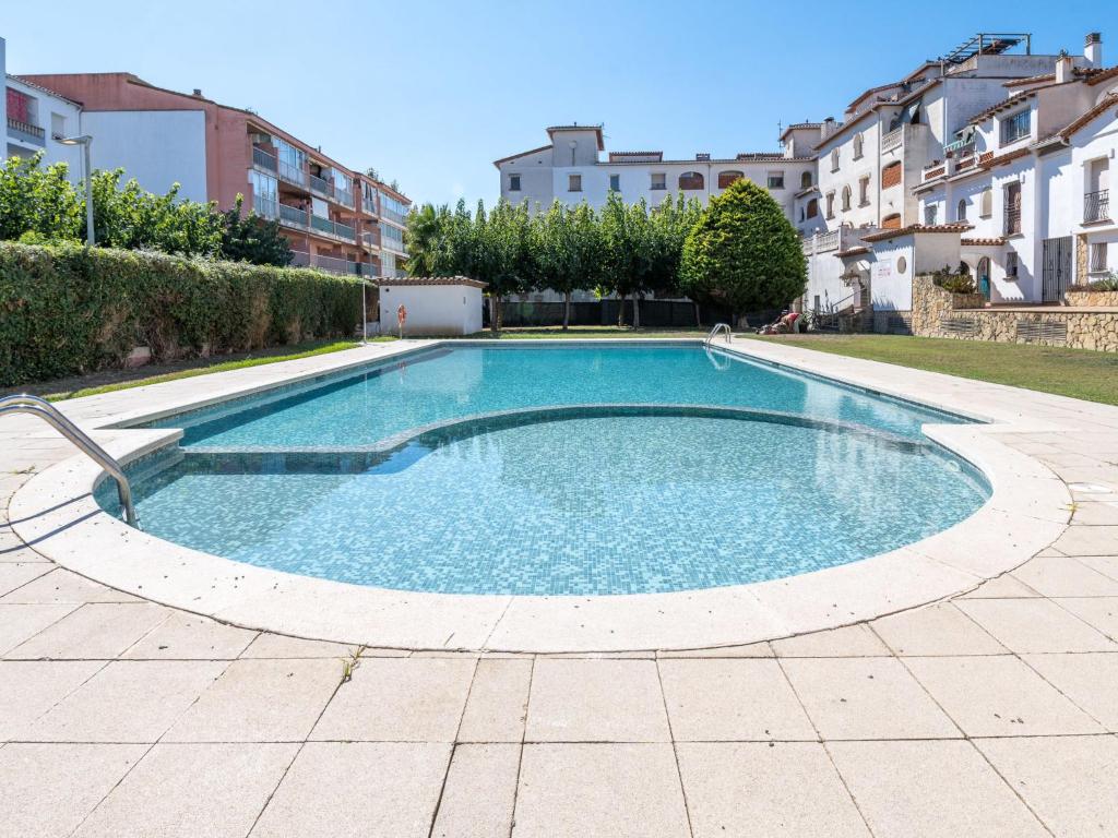 艾姆布里亚布拉瓦Apartment Puigmal by Interhome的一座大型游泳池,位于带建筑物的庭院内