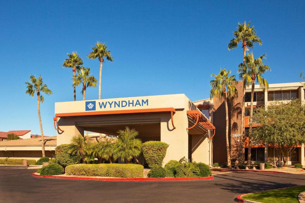 坦培Wyndham Phoenix Airport - Tempe的一座棕榈树建筑和酒店标志