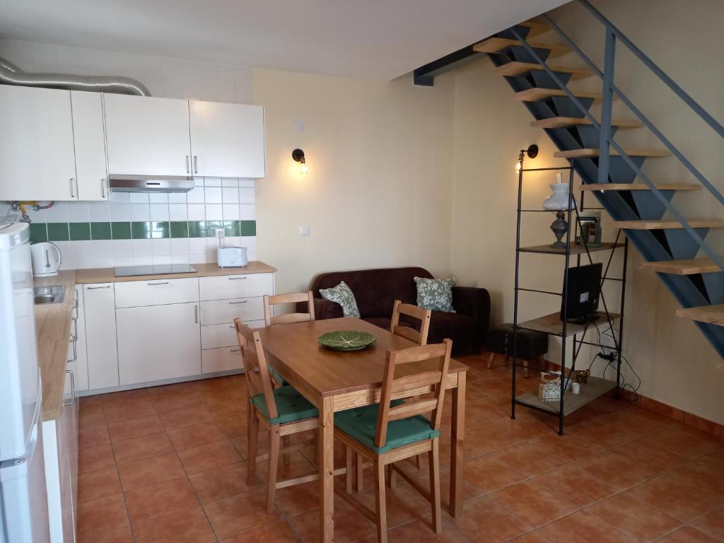 埃武拉Páteo dos Oliveira - Casa da Cocheira的厨房以及带桌子和楼梯的用餐室。