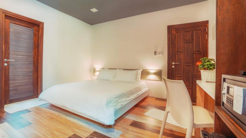 拉斯杜拉斯杜环礁白珊瑚旅馆的白色卧室配有床和椅子