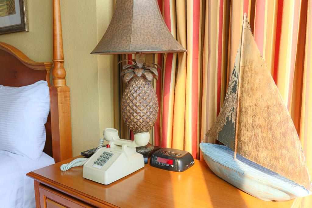 默特尔比奇Schooner II Beach and Racquet Club的一张桌子、电话和床头灯