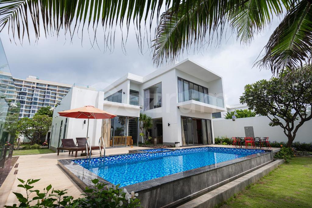 盛日社Cozrum Luxury - Aria Resort Vũng Tàu的别墅前设有游泳池
