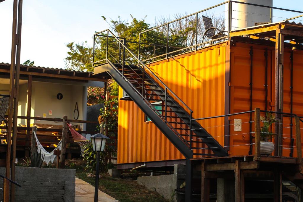 戈亚斯州上帕莱索João de Barro camping e suítes的一座橙色的房子,前面有楼梯