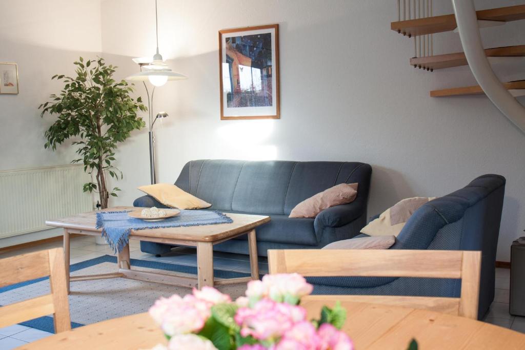 诺德代希Haus Tjalk Ferienhaus Tjalk links的客厅配有蓝色的沙发和桌子