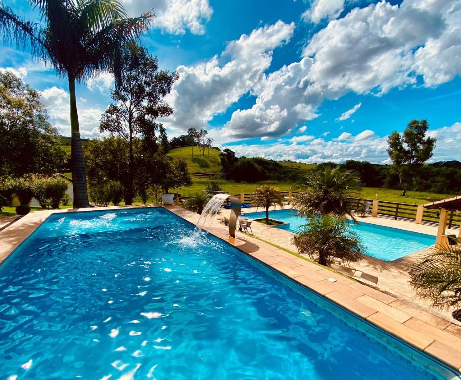 São Sebastião do Rio Verde圣塞巴斯蒂昂旅馆的水中有人的游泳池