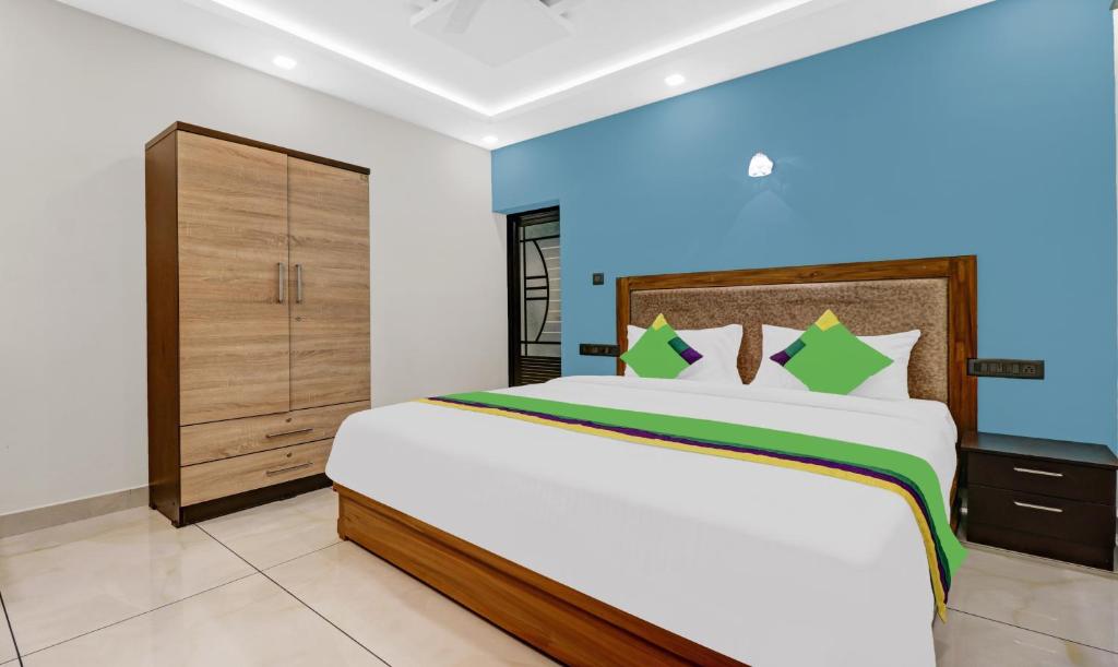 科钦Treebo Trend Pushpak的一间卧室配有一张大床和一个橱柜