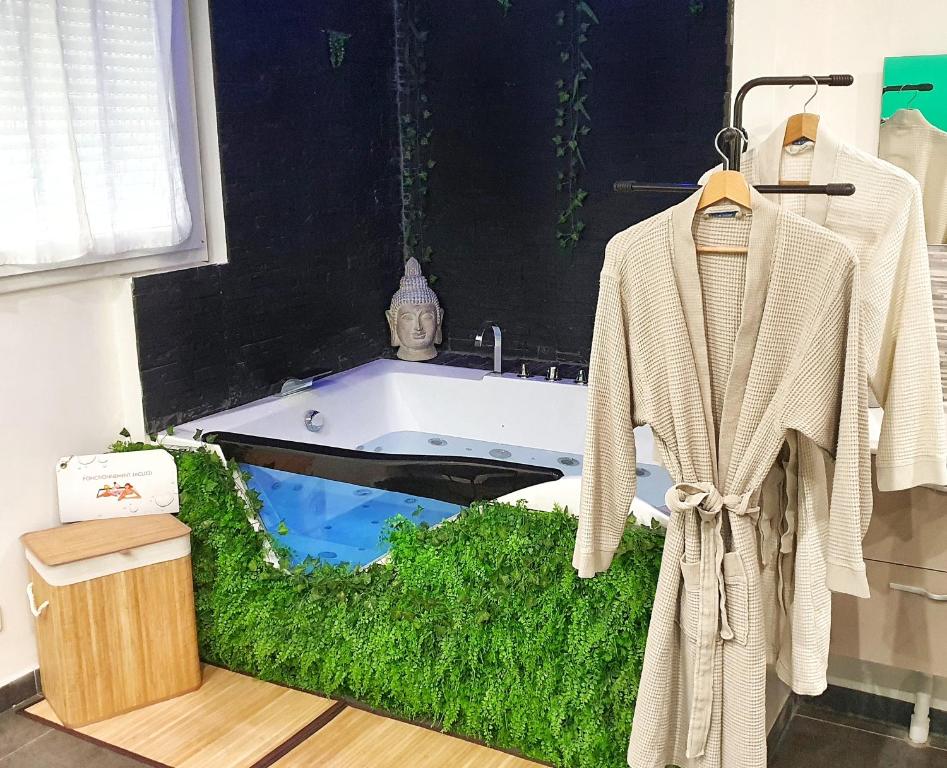 马赛Suite Jacuzzi Privatif Plage Des Catalans的带浴缸的浴室,铺有草地板