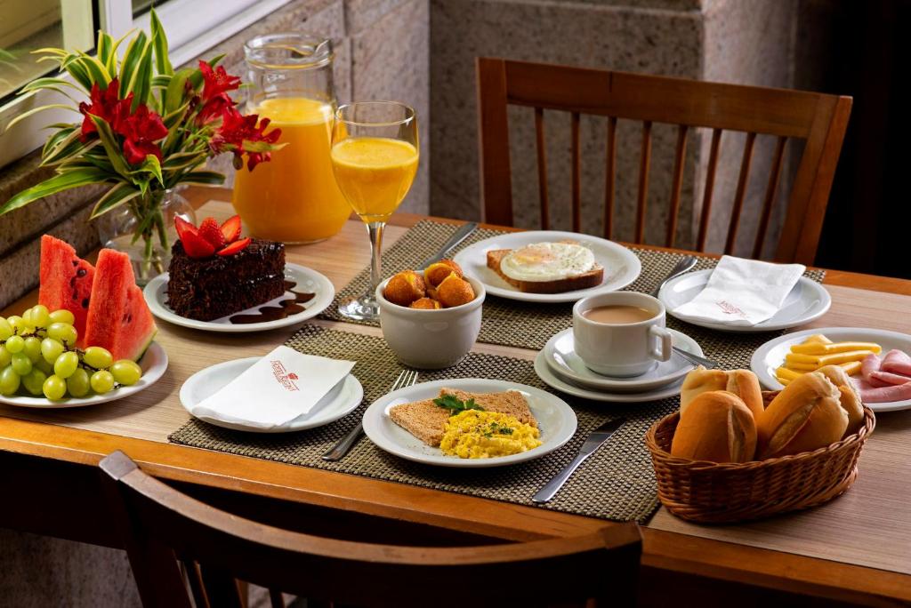 里约热内卢Hotel Regina Rio de Janeiro的餐桌上摆放着早餐食品和饮料