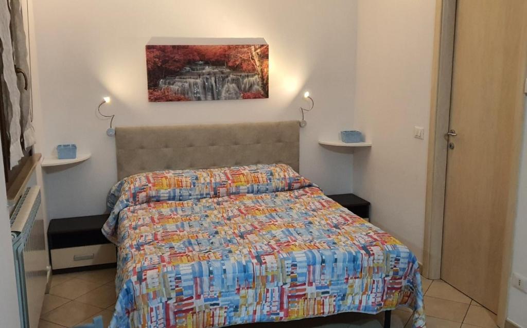 基亚拉瓦莱Sweet Home的卧室配有一张床,墙上挂有绘画作品