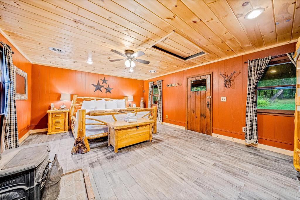 MinervaMinerva's Log Cabin Gem的一间卧室拥有橙色的墙壁和一张床铺,天花板