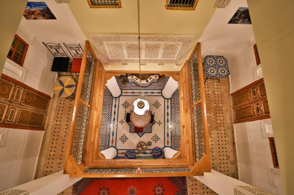 非斯Riad Fes Unique的一间设有摩洛哥地毯的房间和一间带天花板的房间