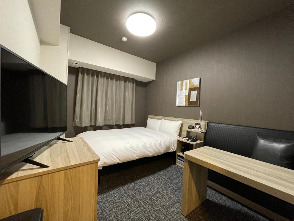 MitsukeHotel Route Inn Mitsuke -Nakanoshima Mitsuke Inter-的配有一张床和一台平面电视的酒店客房